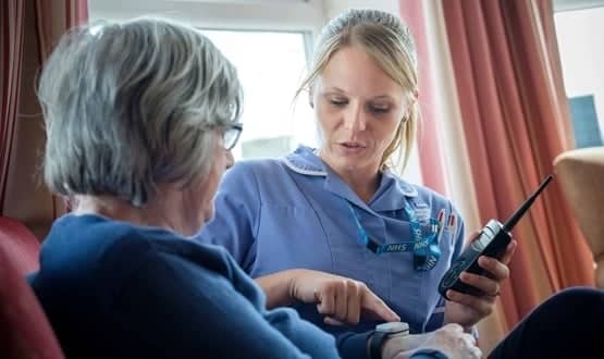 A care home nurse in Calderdale teaches a resident how their technology works