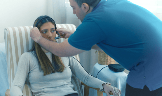 A woman is fitted with the headset-style EyeControl wearable device for locked-in patients