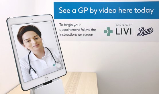 A female GP from Livi appears on a tablet computer in a Boots consultation room